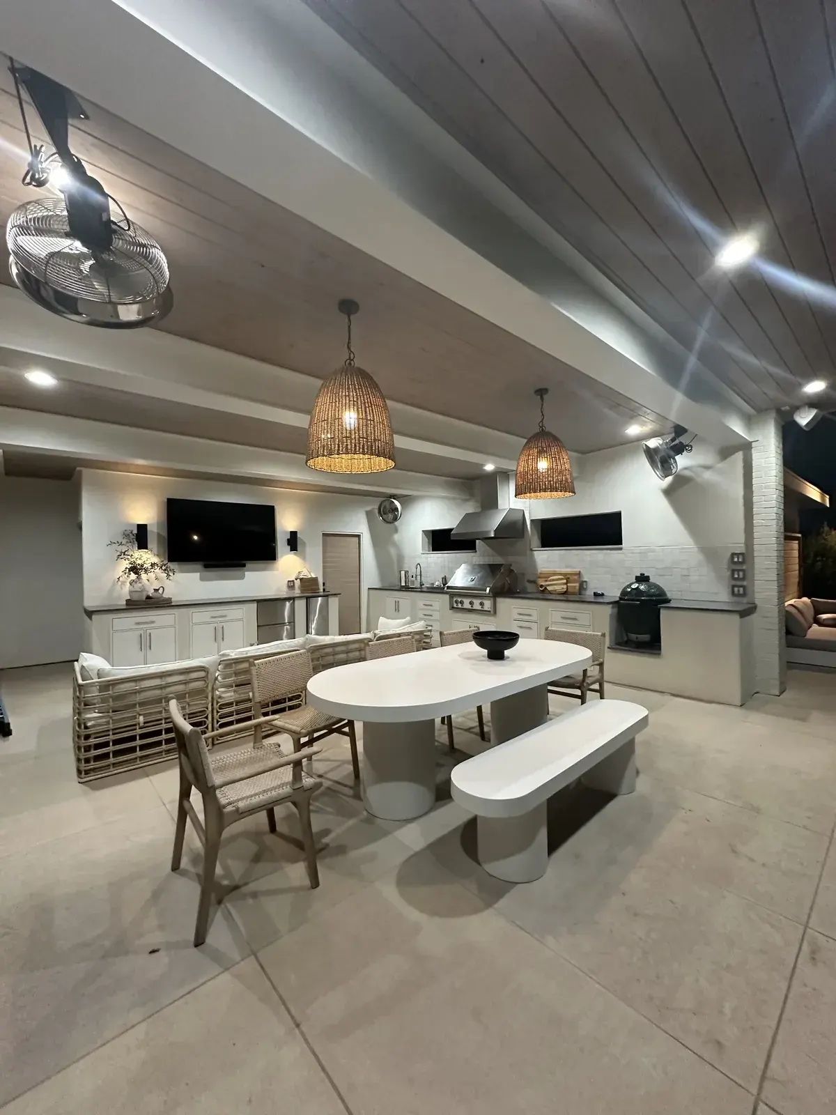 Finished covered patio with dining seating and lighting in the evening