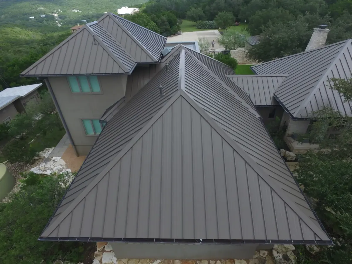 Close aerial view of standing-seam metal roof hips and intersecting roof planes